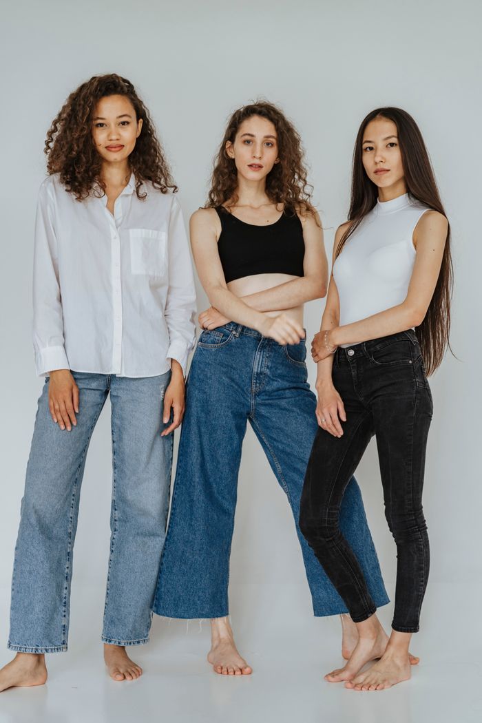 services-03 Three women in casual outfits pose stylishly indoors, showcasing modern fashion trends.
